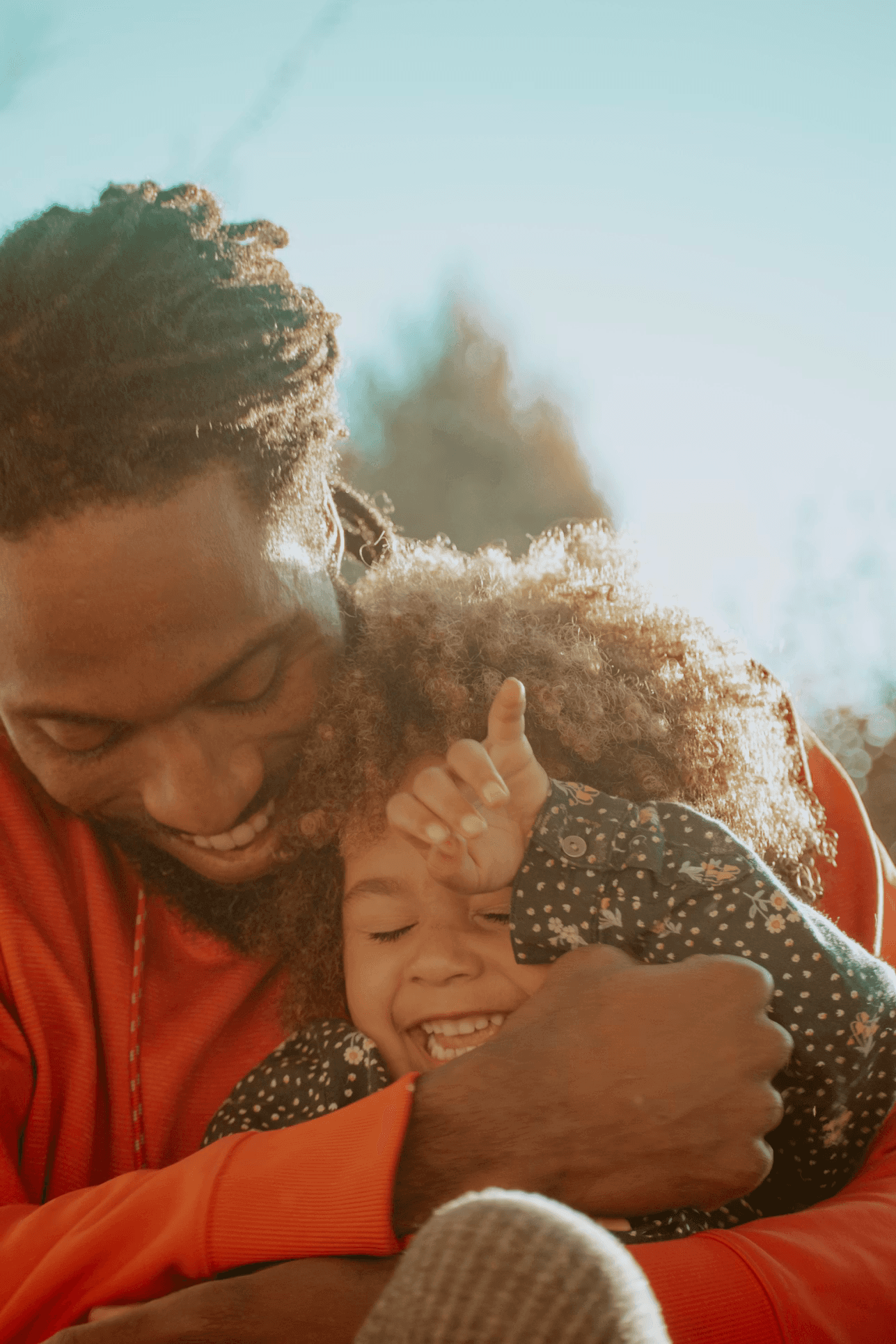 A happy father lifting his daughter up in the air for sunset